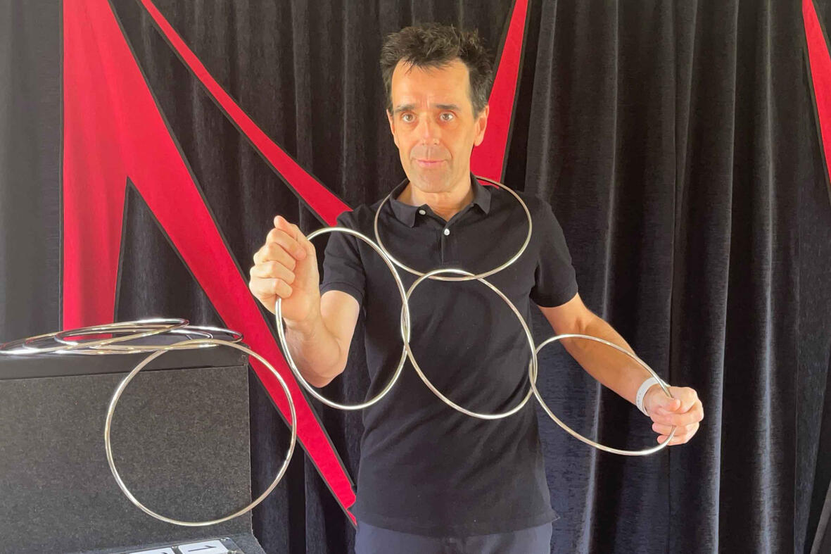 Monsieur Fred réalise un tour de magie où une corde est coupée puis raccommodée sous les yeux étonnés du public lors du spectacle.