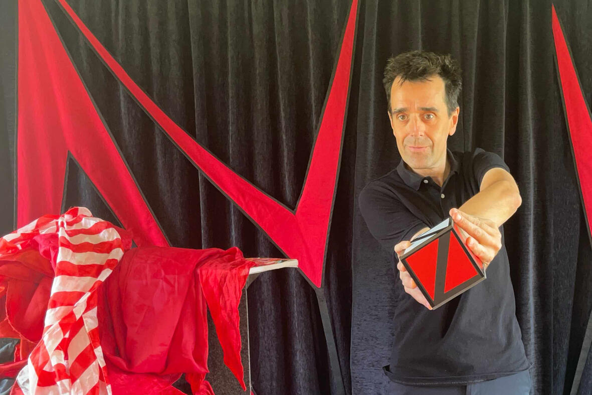 Monsieur Fred réalise une prédiction mentaliste avec des cartes et un album à timbres lors d’un spectacle interactif pour seniors et familles.