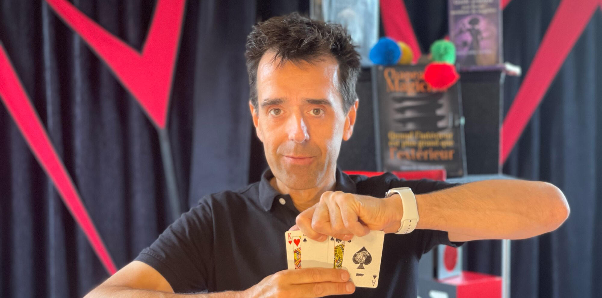 Monsieur Fred fait apparaître un lapin en peluche à partir d’un foulard, entouré de ballons rouges, lors d’un numéro de magie pour ccas