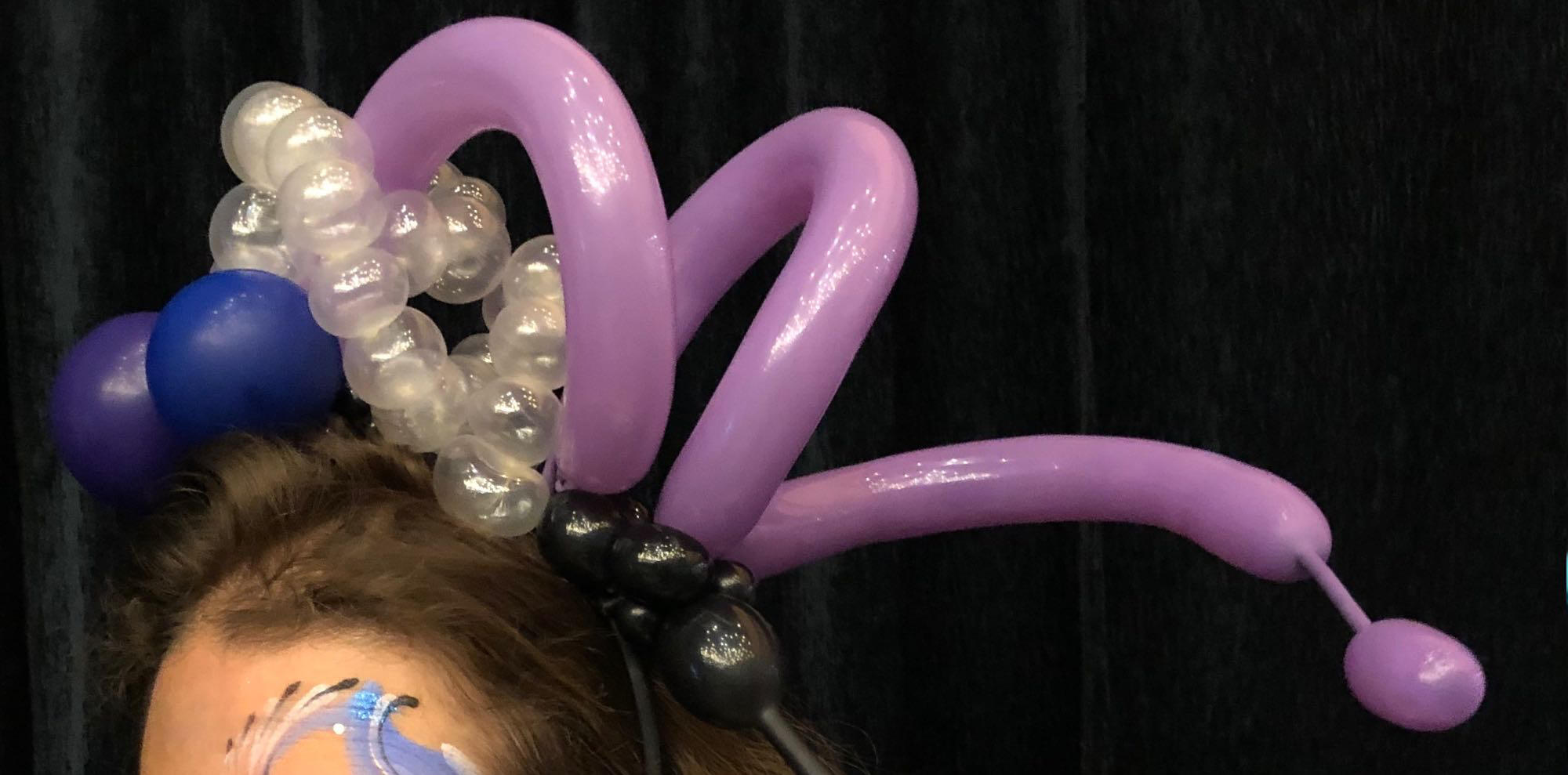 Différents modèles de ballons sculptés exposés pendant un événement festif pour seniors